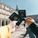 Anonymous tourists showing US passports on street on sunny day