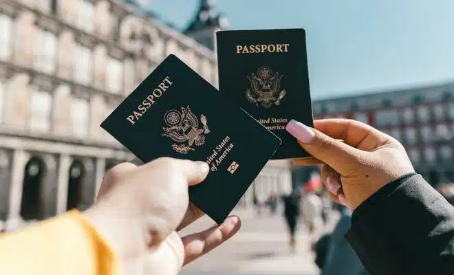 Anonymous tourists showing US passports on street on sunny day