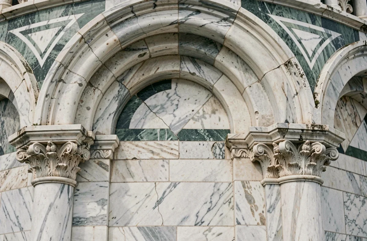 Détail architectural en marbre de Carrare avec arcades romanes et incrustations géométriques sur la cathédrale de Pise