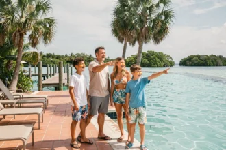 Famille en vacances au bord de la piscine lagon turquoise du Coral Lagoon Resort à Marathon, Florida Keys