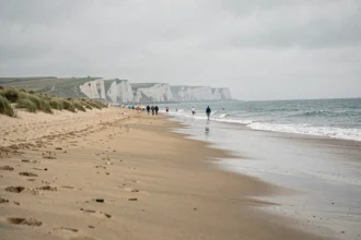 Vue panoramique d'une plage de sable de la côte d'Opale dans les Hauts-de-France avec des falaises blanches en arrière-plan