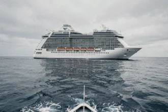Grand bateau de croisière moderne naviguant en pleine mer, vue extérieure grand angle depuis l'eau