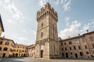 Vue grand angle de la Tour de Pise s'élevant au-dessus de la place historique avec ses détails architecturaux médiévaux en pierre